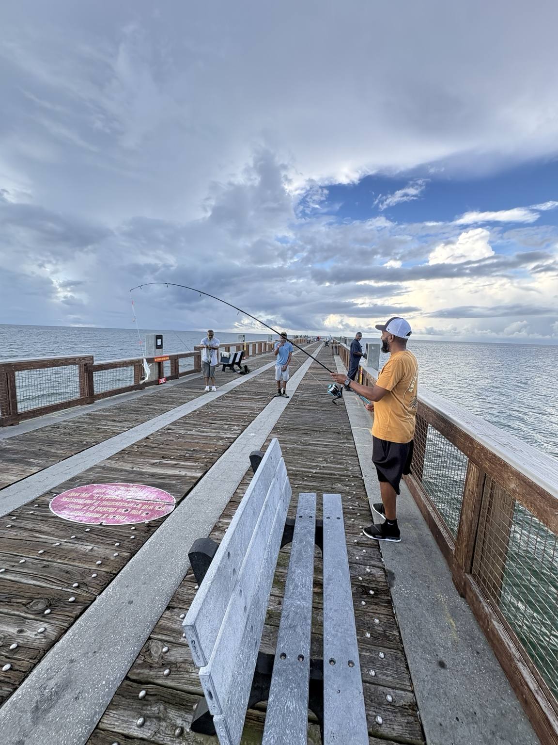 Family member fishing beneath a dramatic sky
