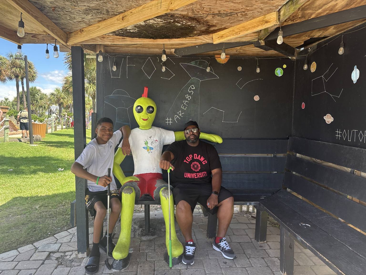 Family members posing with a playful alien display